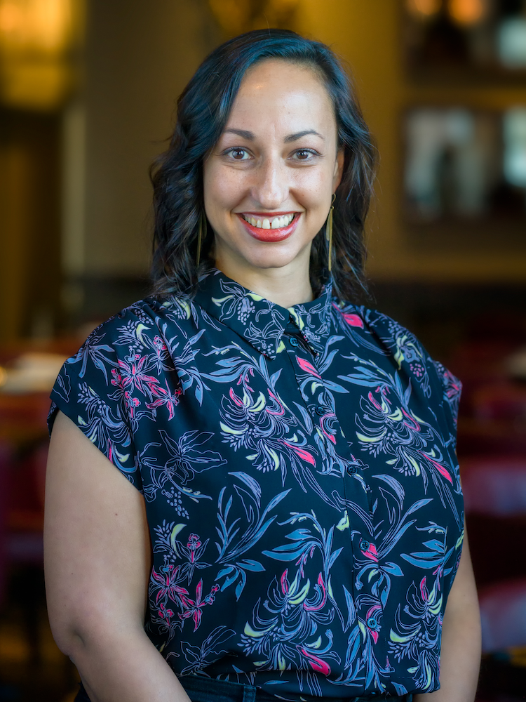 Woman in floral shirt looks at the camera and smiles