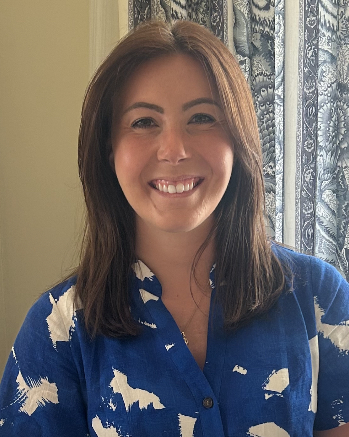 woman in blue shirt looks at camera and smiles