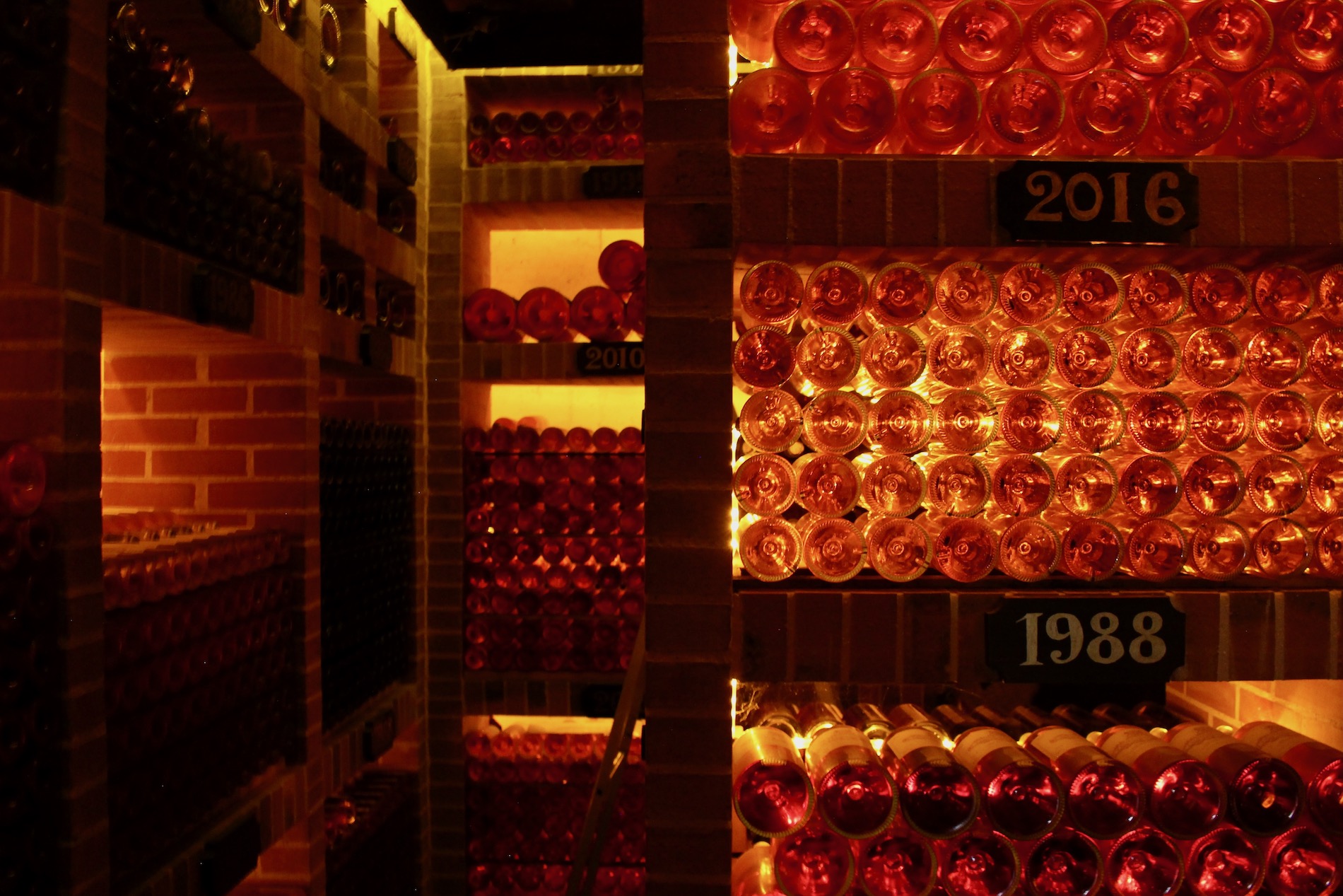 Golden light behind bottles in a cellar