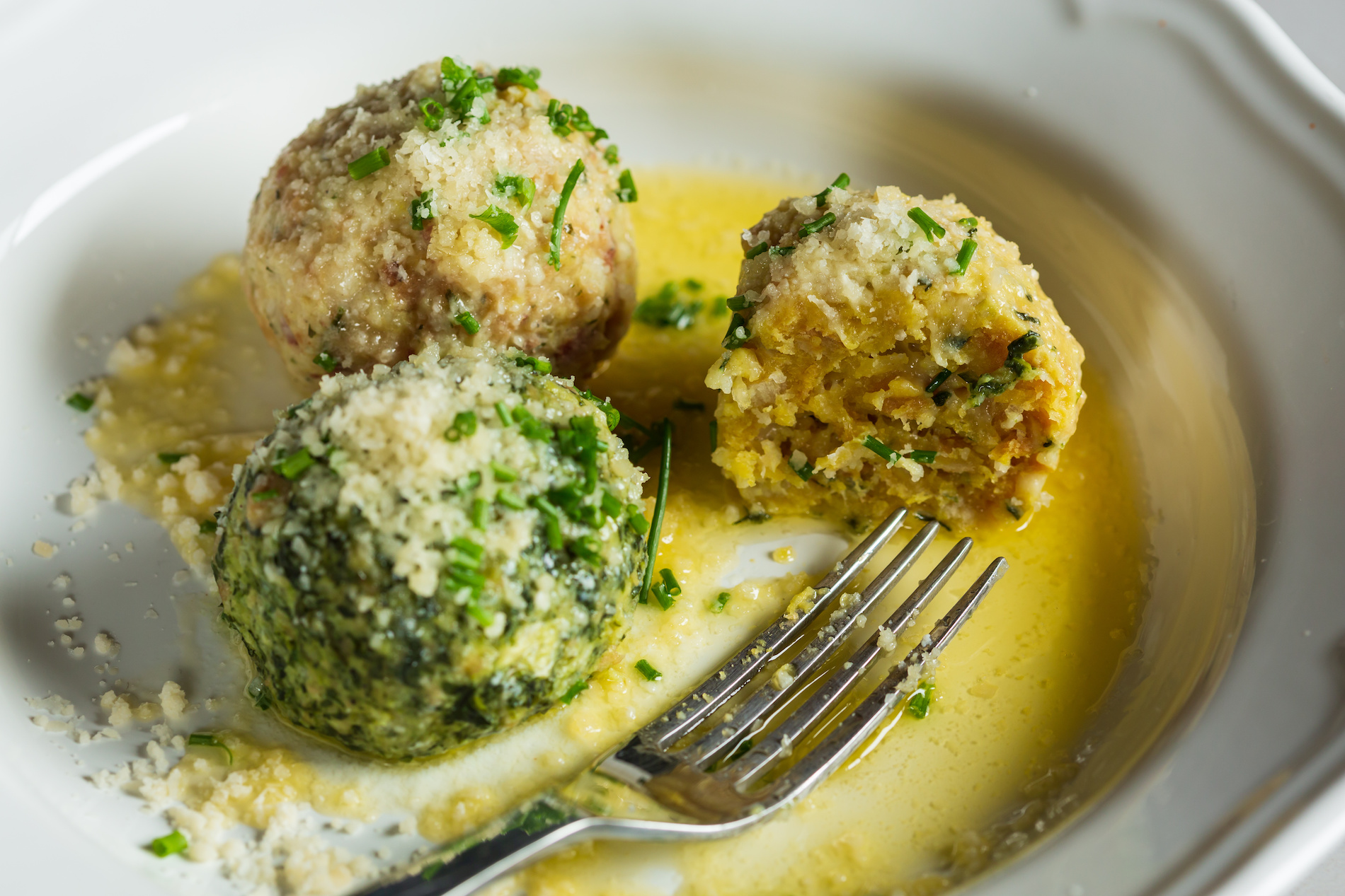 Round dumplings made with meat and bright green herbs