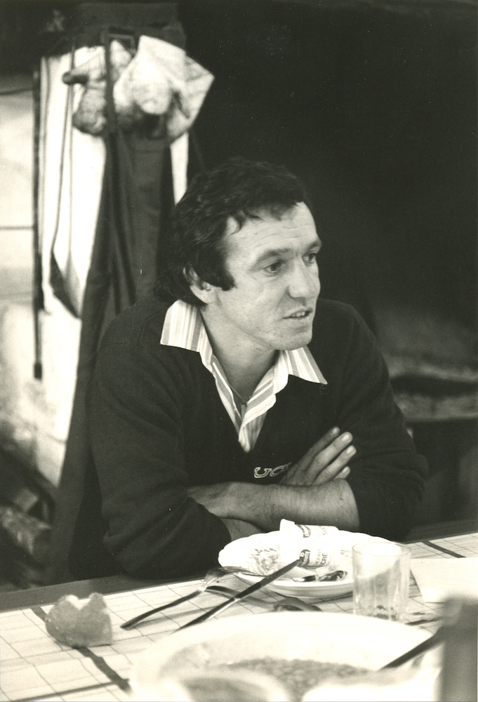 Man sits at table in conversation in black-and-white photo