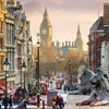 Buildings lining a street filled with people with Big Ben in the background