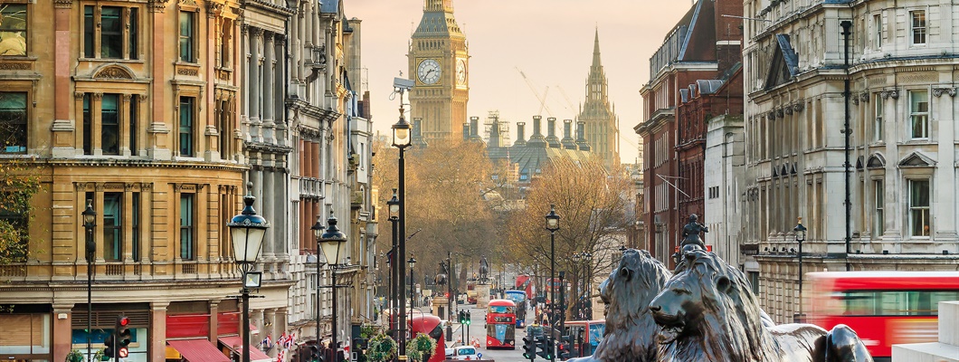 Buildings lining a street filled with people with Big Ben in the background