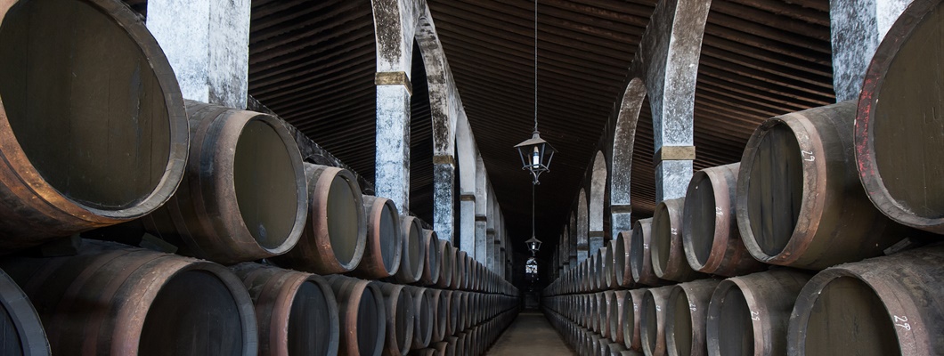 rows of stacked barrels in a wine cellar