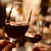 Close-up of red wine glasses held up to toast