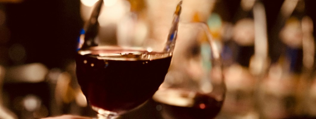 Close-up of red wine glasses held up to toast