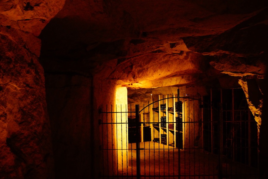 Dark cellar with orange glow and bottles visible in the distance