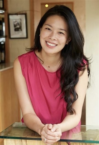 Woman in pink shirt looks at camera, smiling