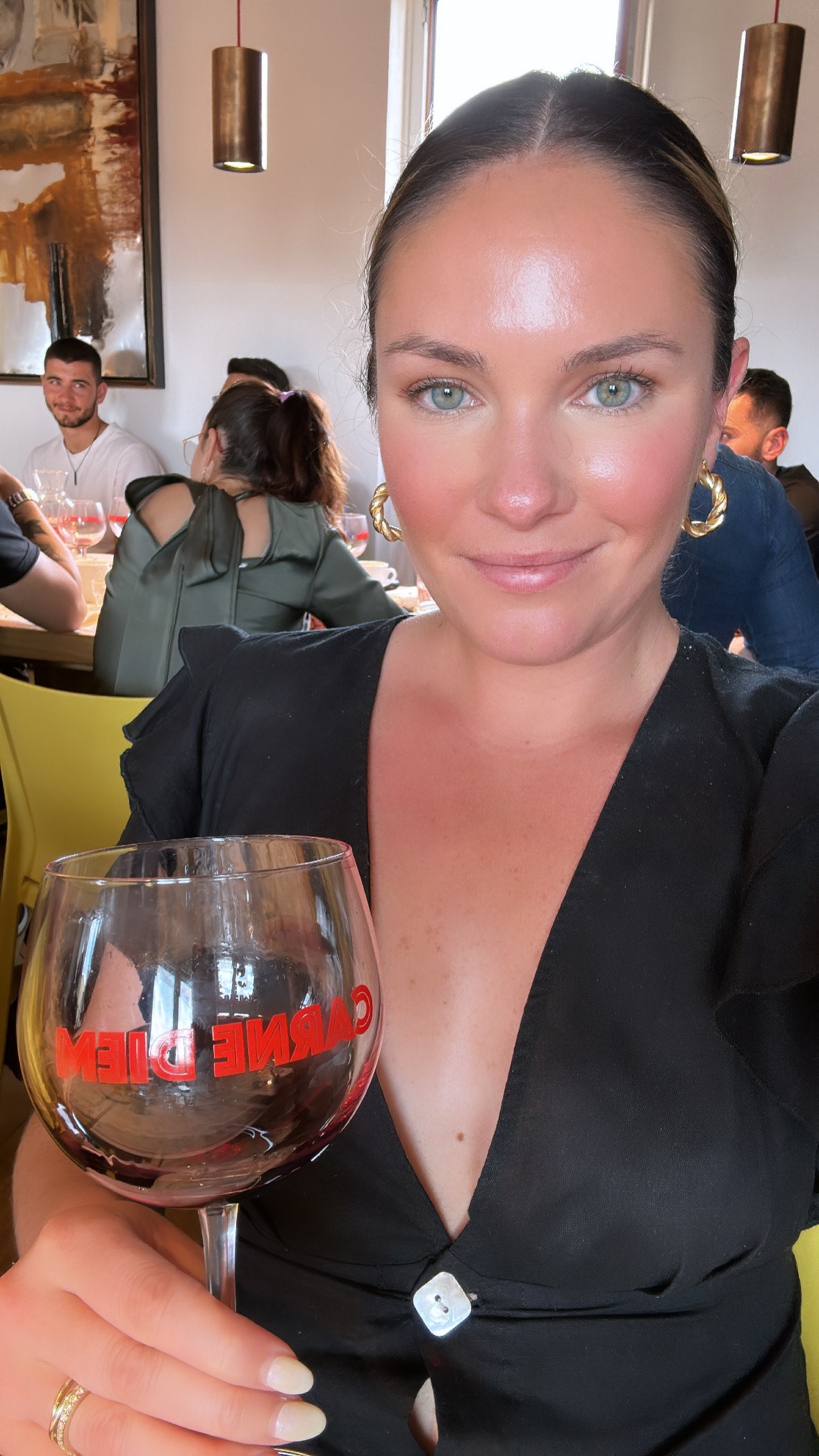 Woman in black dress holding wine glass